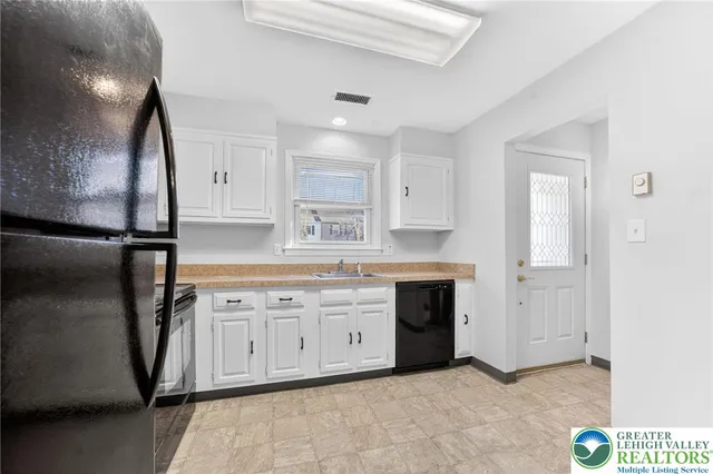 a kitchen with granite countertop a sink cabinets stainless steel appliances and a counter top space