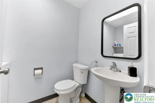 a bathroom with a toilet sink and mirror