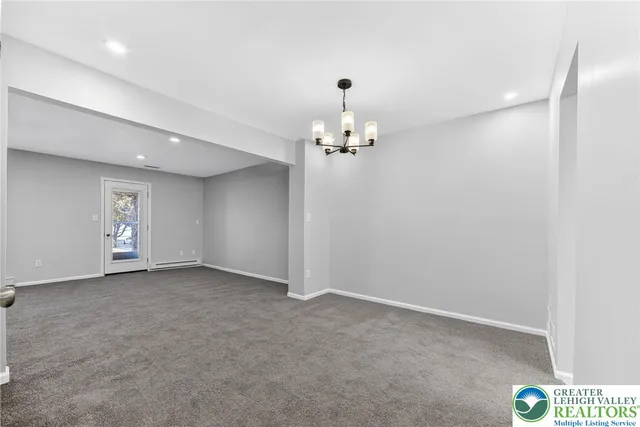 an empty room with a chandelier fan