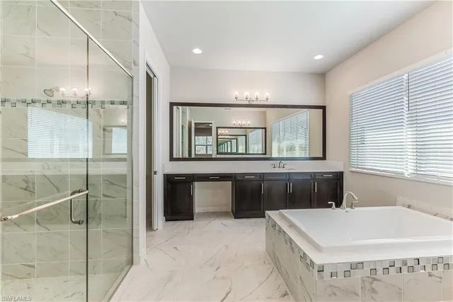 a spacious bathroom with a granite countertop tub sink and mirror