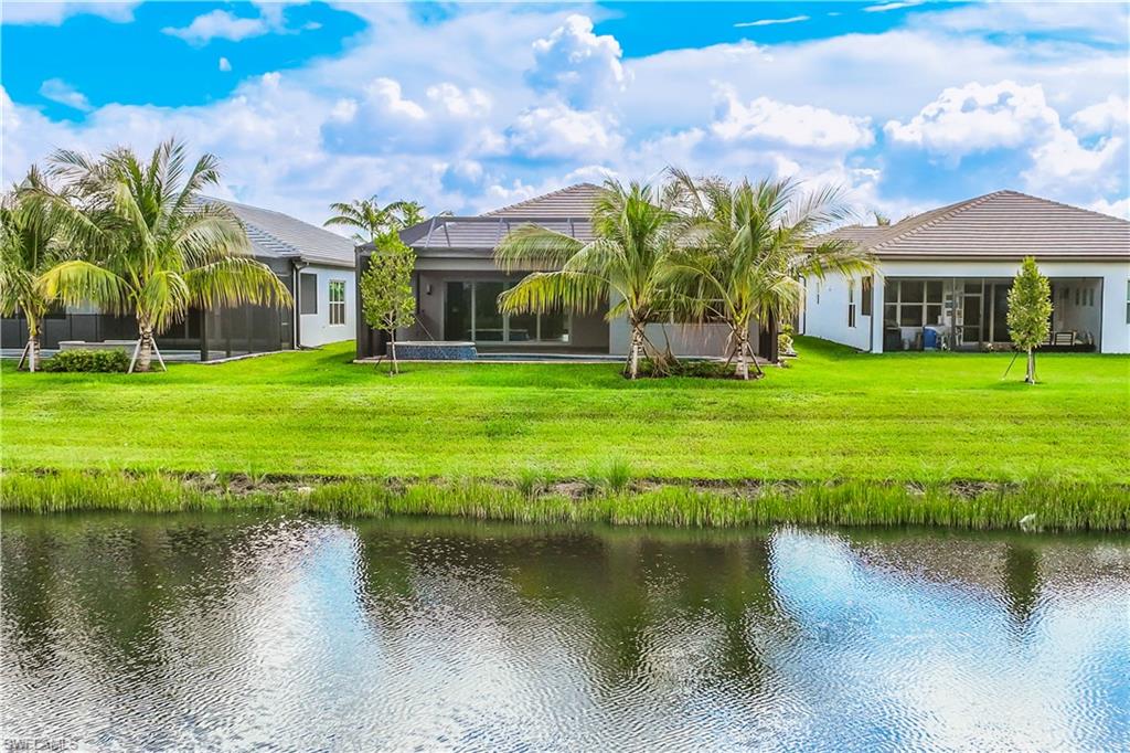 11847 Hydrangea Place Naples, FL 34120 - Photo 24 of 30 a view of a house with a yard and a pond