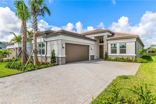 a front view of a house with a yard and a garage