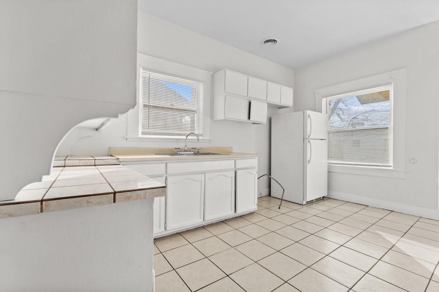 4354 East Kings Canyon Road Fresno, CA 93702 - Photo 13 of 87 a kitchen with a cabinets and white appliances