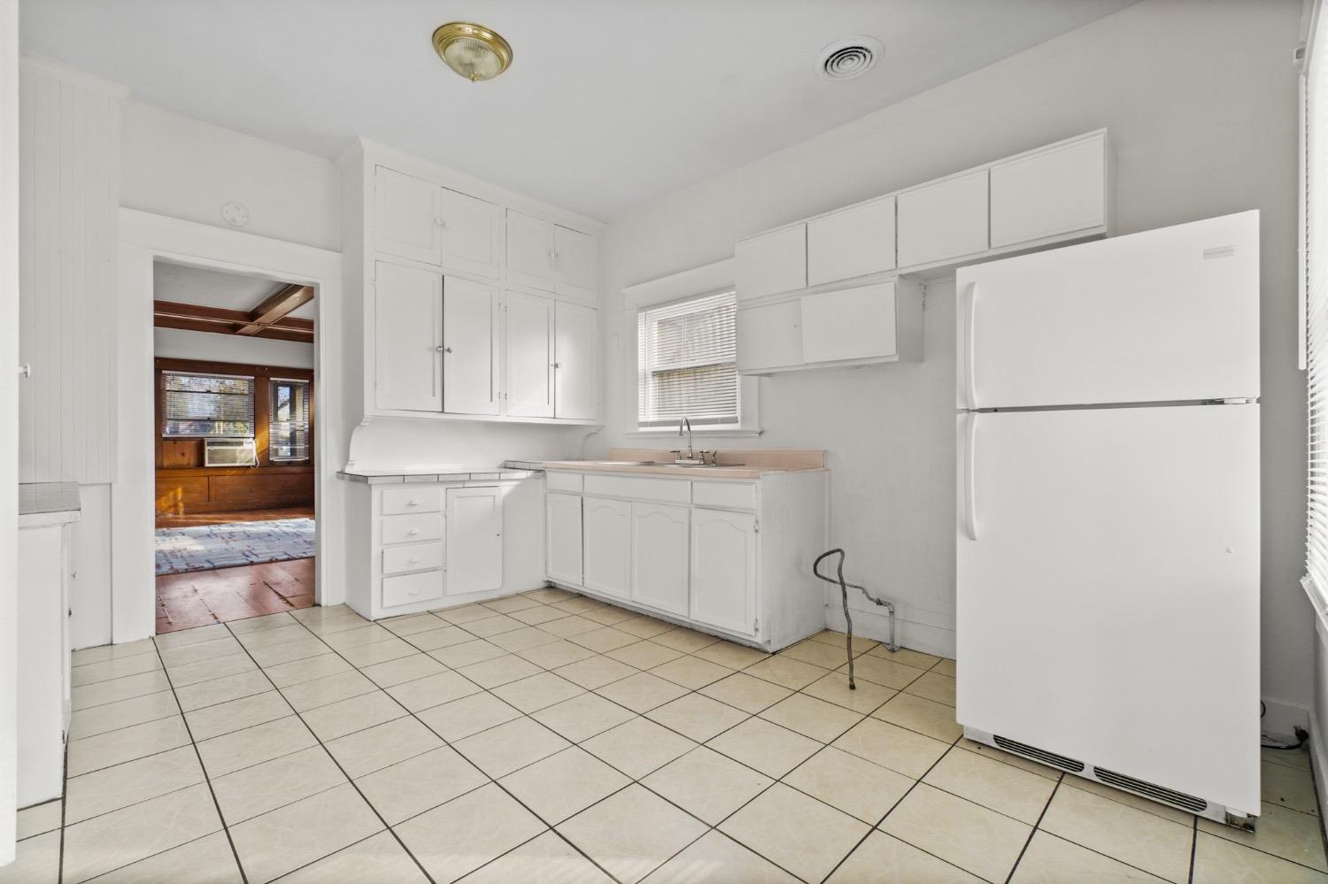 4354 East Kings Canyon Road Fresno, CA 93702 - Photo 16 of 87 a kitchen with a refrigerator a stove top oven and white cabinets