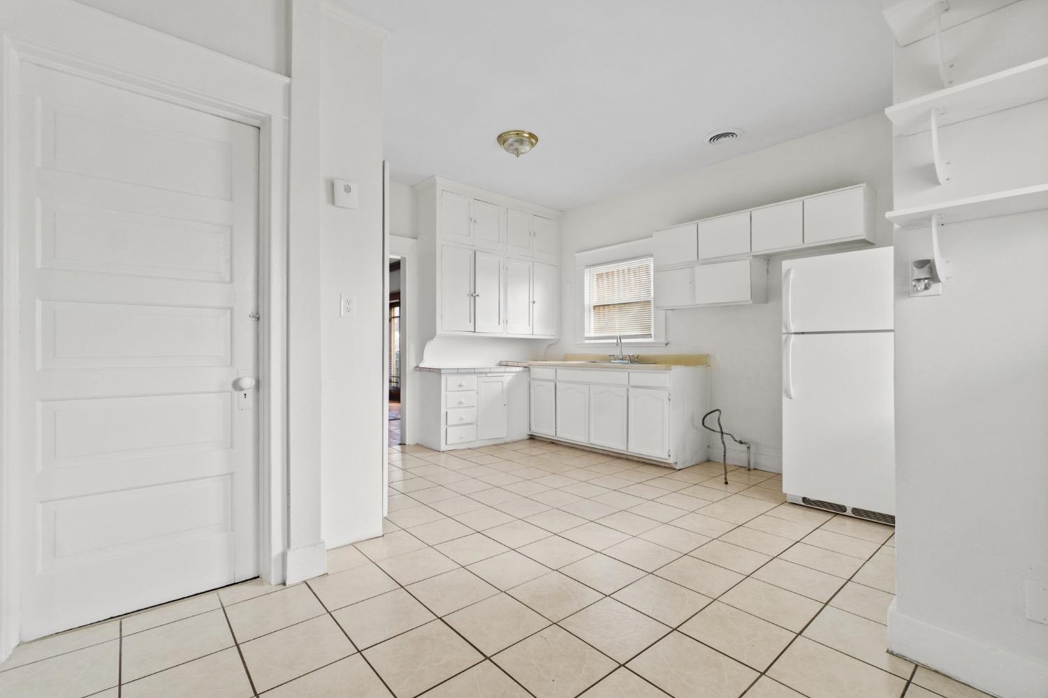 4354 East Kings Canyon Road Fresno, CA 93702 - Photo 17 of 87 a kitchen with white cabinets and white appliances