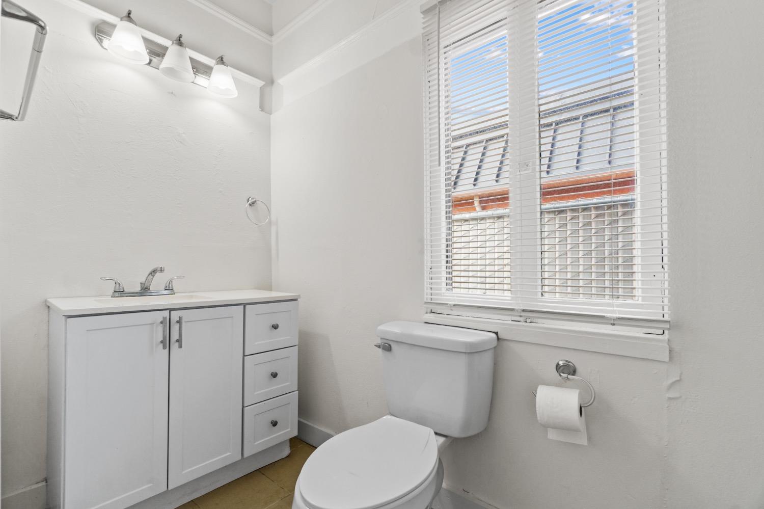 4354 East Kings Canyon Road Fresno, CA 93702 - Photo 21 of 87 a white toilet sitting next to a bathroom sink