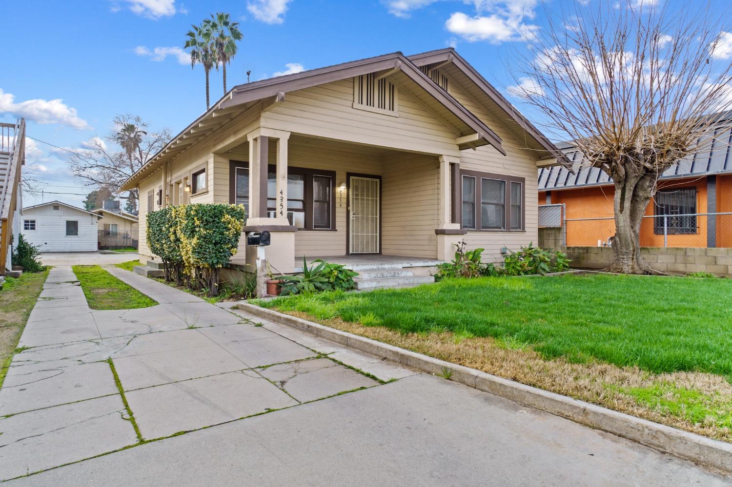 4354 East Kings Canyon Road Fresno, CA 93702 - Photo 4 of 87 a front view of a house with a yard and potted plants