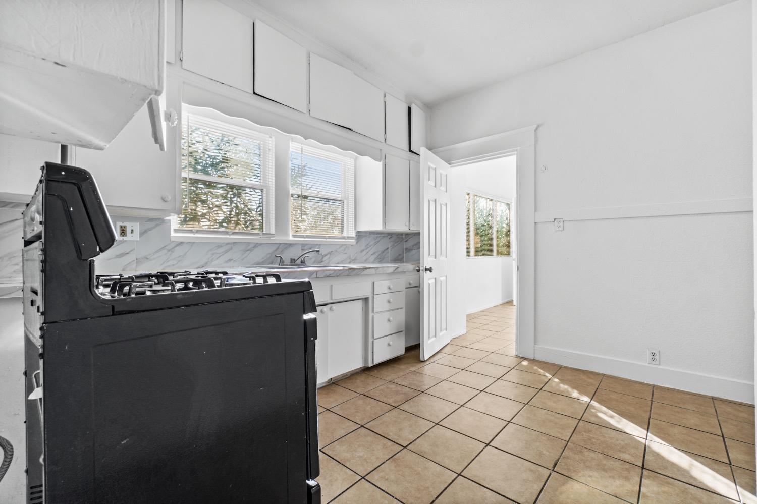 4354 East Kings Canyon Road Fresno, CA 93702 - Photo 41 of 87 a kitchen with granite countertop a sink stove and cabinets