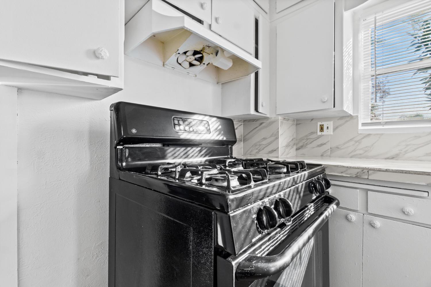 4354 East Kings Canyon Road Fresno, CA 93702 - Photo 42 of 87 a white stove top oven sitting inside of a kitchen