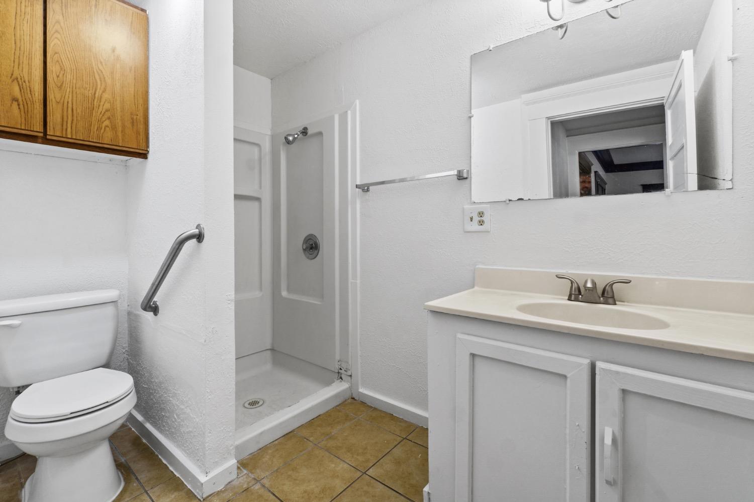 4354 East Kings Canyon Road Fresno, CA 93702 - Photo 50 of 87 a bathroom with a granite countertop sink toilet and shower