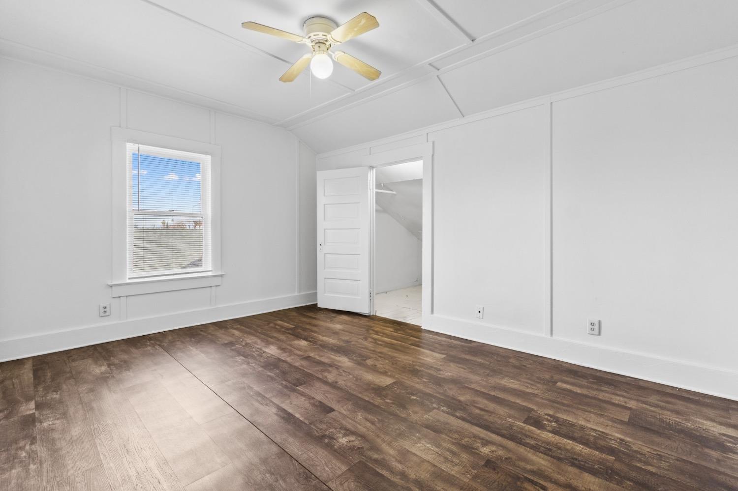 4354 East Kings Canyon Road Fresno, CA 93702 - Photo 71 of 87 an empty room with wooden floor chandelier fan and windows