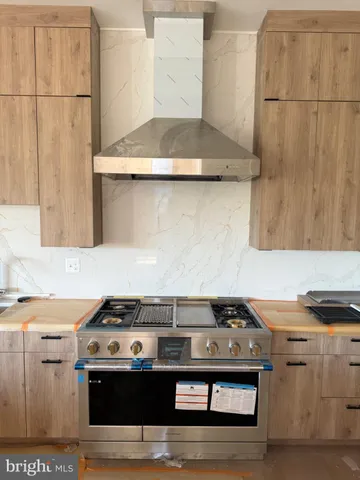 a stove top oven sitting inside of a kitchen