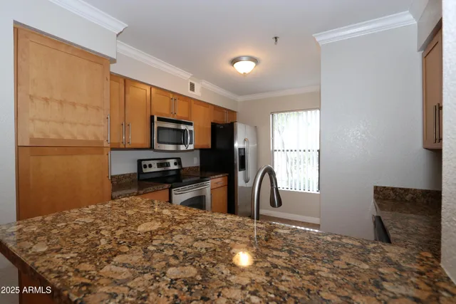 a kitchen with granite countertop a refrigerator and a sink