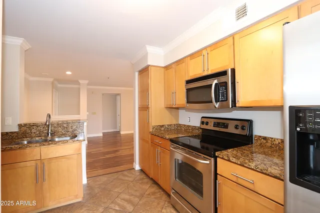 a kitchen with stainless steel appliances granite countertop a stove a sink and a microwave
