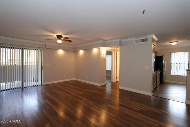 an empty room with wooden floor and windows
