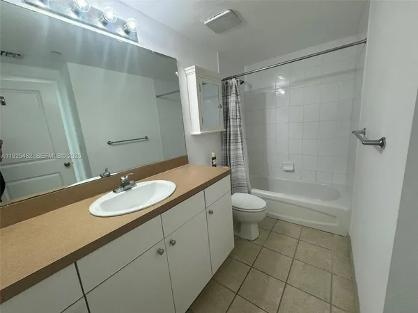 a bathroom with a granite countertop sink toilet a large mirror a shower and a bathtub