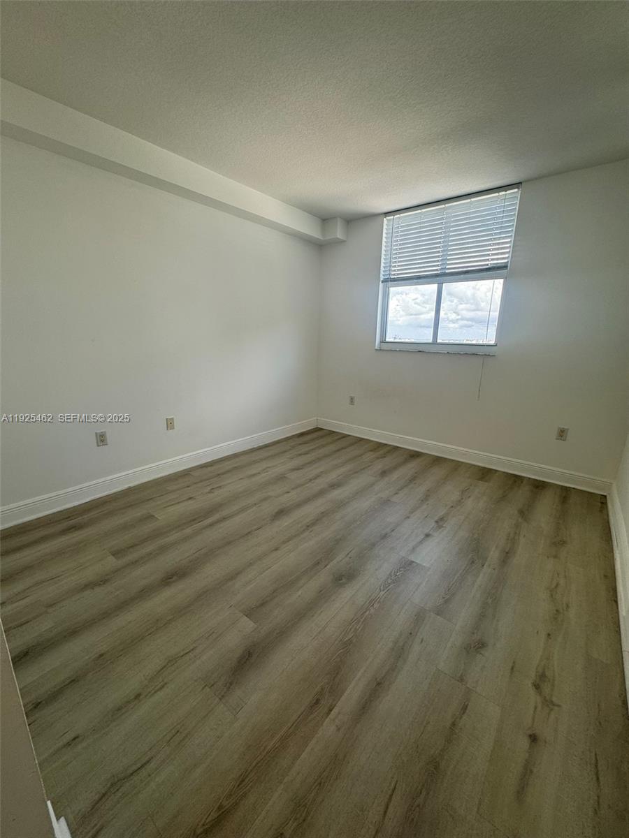 1250 South Miami Avenue, Unit 2805 Miami, FL 33130 - Photo 15 of 30 an empty room with wooden floor and windows