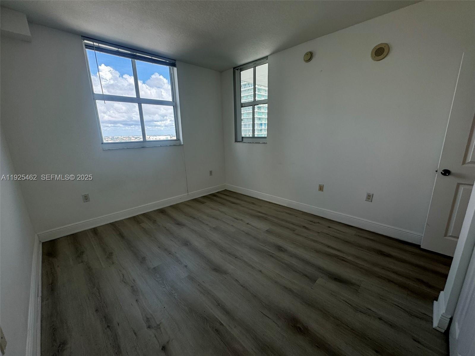 1250 South Miami Avenue, Unit 2805 Miami, FL 33130 - Photo 16 of 30 an empty room with wooden floor and windows