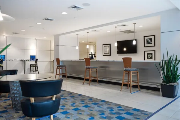 a living room with furniture a flat screen tv and kitchen view