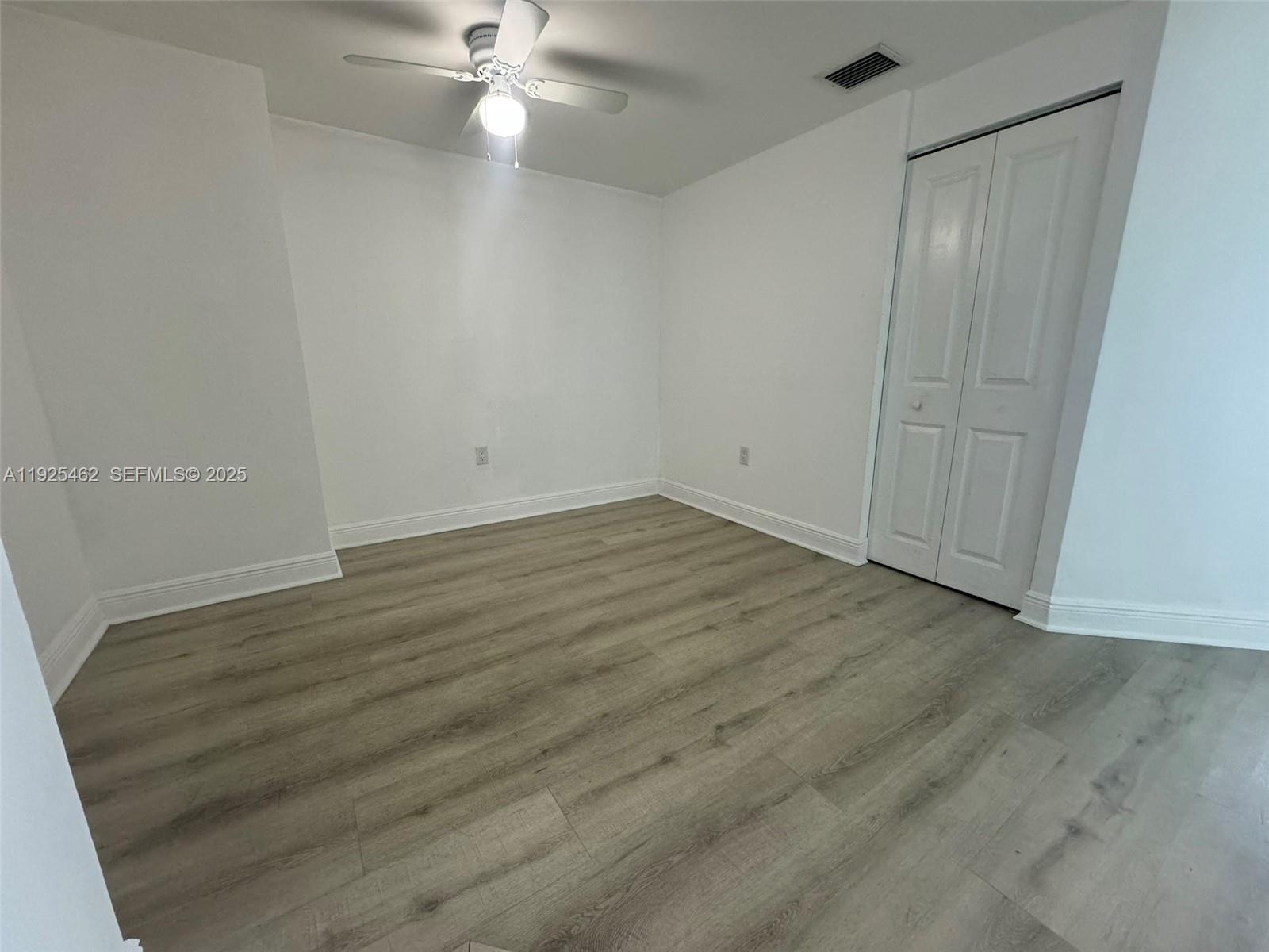 1250 South Miami Avenue, Unit 2805 Miami, FL 33130 - Photo 3 of 30 an empty room with wooden floor and fan
