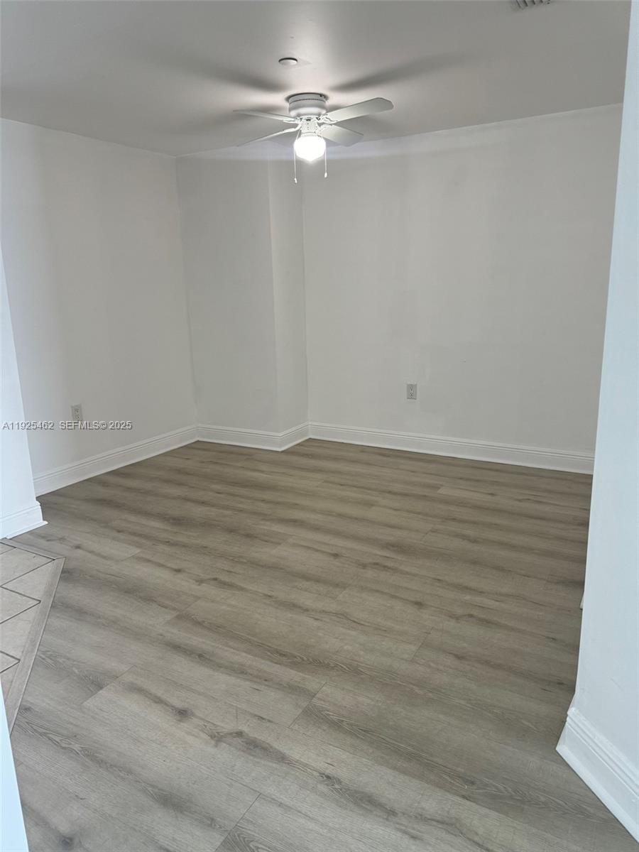 1250 South Miami Avenue, Unit 2805 Miami, FL 33130 - Photo 5 of 30 an empty room with wooden floor fan and windows