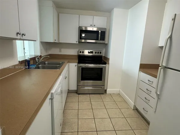 a kitchen with granite countertop a stove and a refrigerator