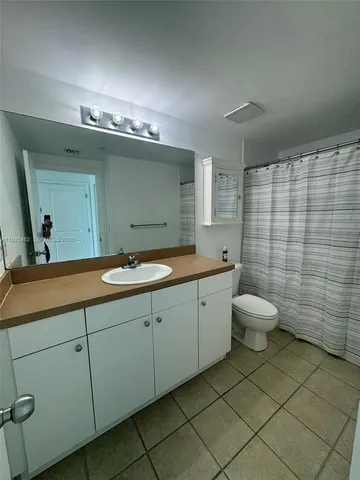 a bathroom with a double vanity sink mirror and toilet