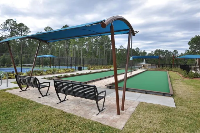 a view of a swimming pool with outdoor seating and a palm tree