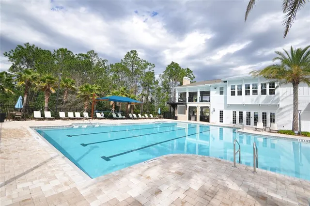 a kitchen with stainless steel appliances granite countertop a stove a refrigerator a kitchen island a table and chairs