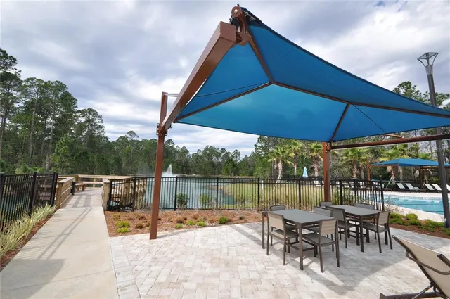 a kitchen with stainless steel appliances granite countertop a stove a sink dishwasher a dining table and chairs with wooden floor