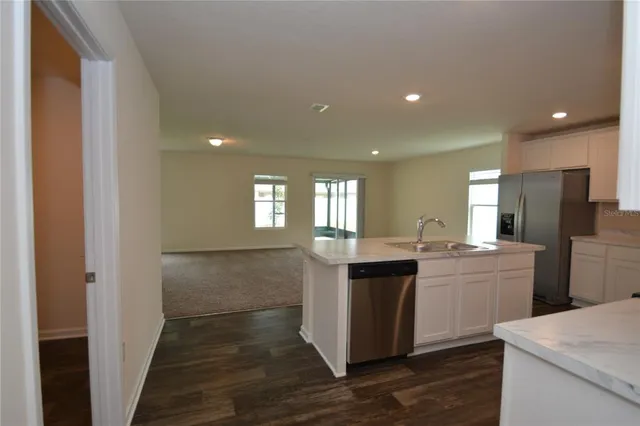 a kitchen with kitchen island white cabinets appliances and sink