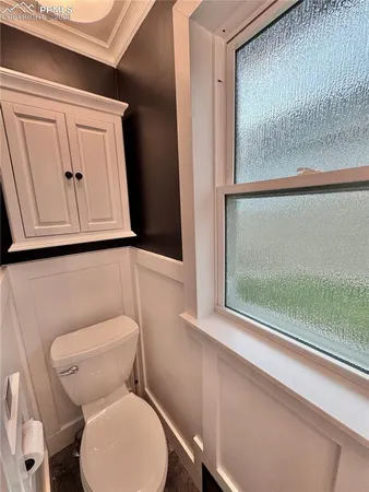 a white toilet sitting next to a window