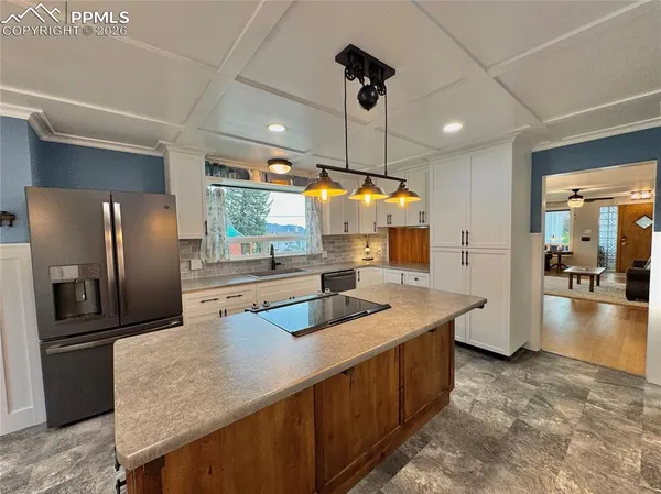 a kitchen with stainless steel appliances granite countertop a sink a refrigerator and a stove