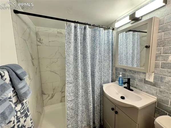 a bathroom with a sink a toilet and shower curtain