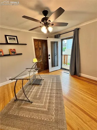 a view of a livingroom with wooden floor and a ceiling fan