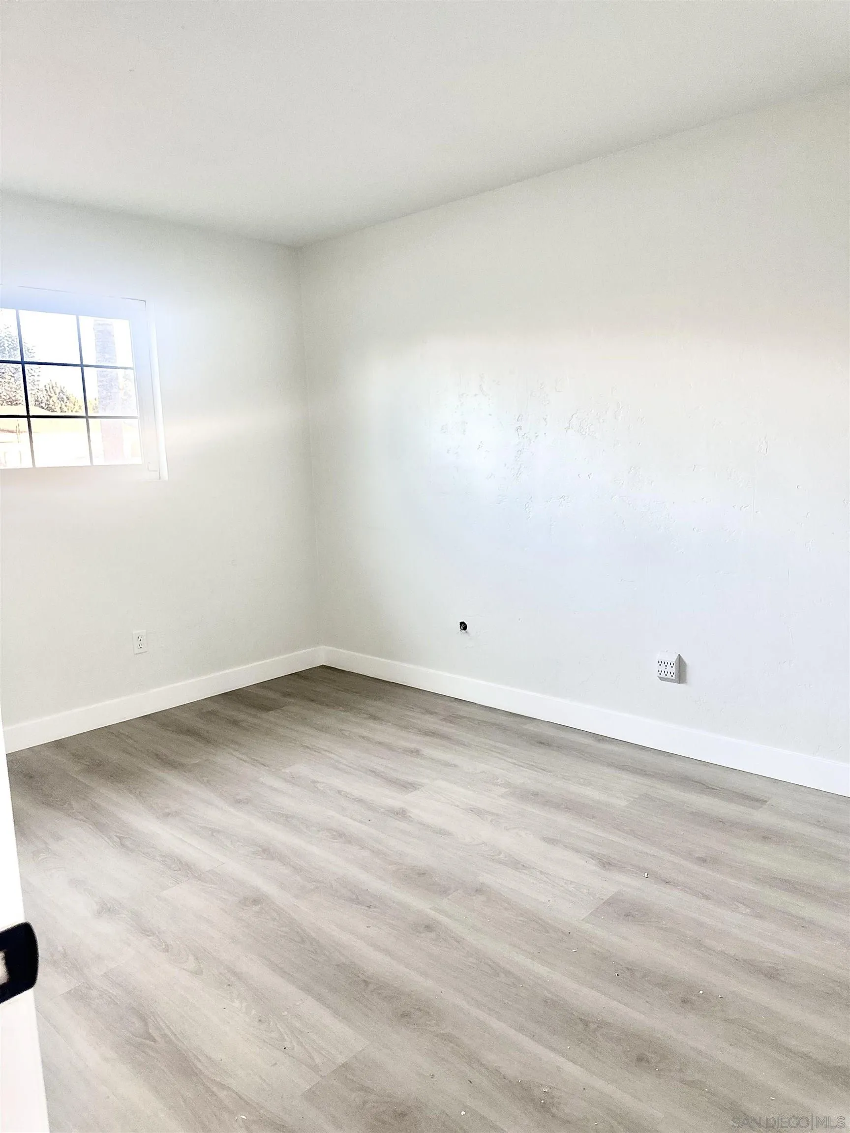 13534 Mountainside Drive Poway, CA 92064 - Photo 5 of 9 an empty room with wooden floor and windows