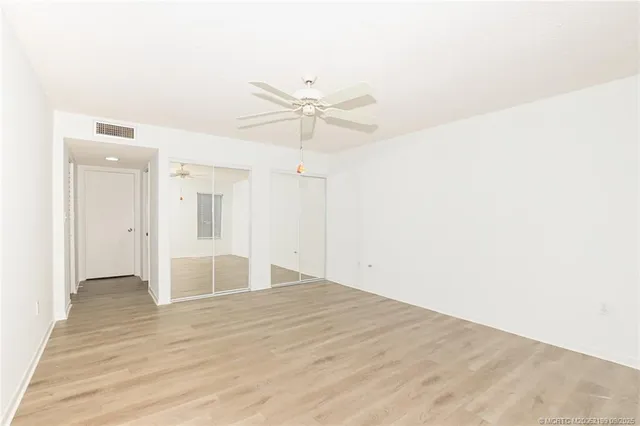 a view of empty room with wooden floor