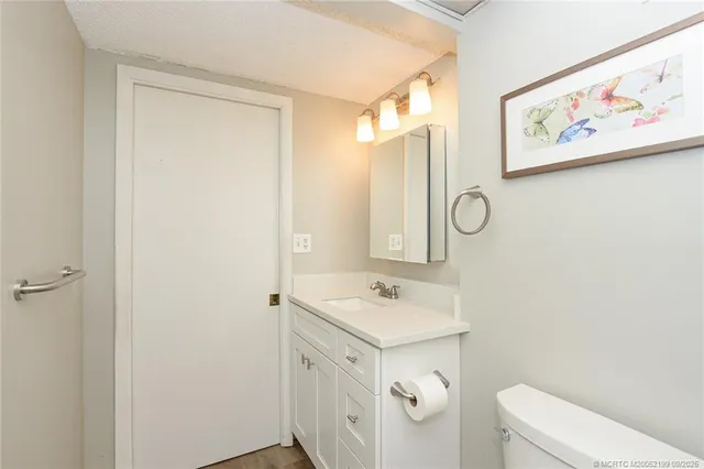 a bathroom with a sink mirror vanity and toilet