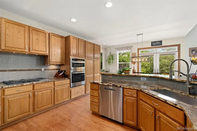 a kitchen with stainless steel appliances granite countertop a stove a sink and a refrigerator