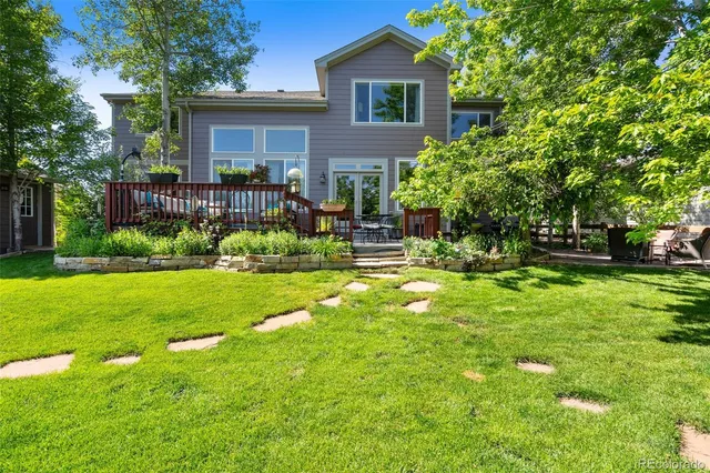 a front view of a house with a garden and trees