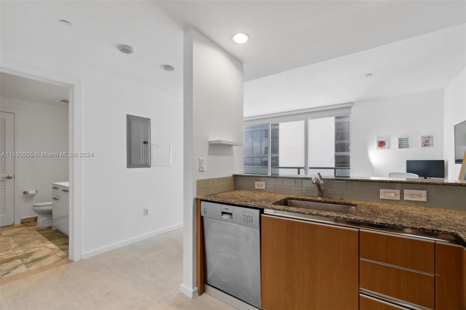 1050 Brickell Avenue, Unit 2422 Miami, FL 33131 - Photo 6 of 21 a kitchen with granite countertop a sink and a stove