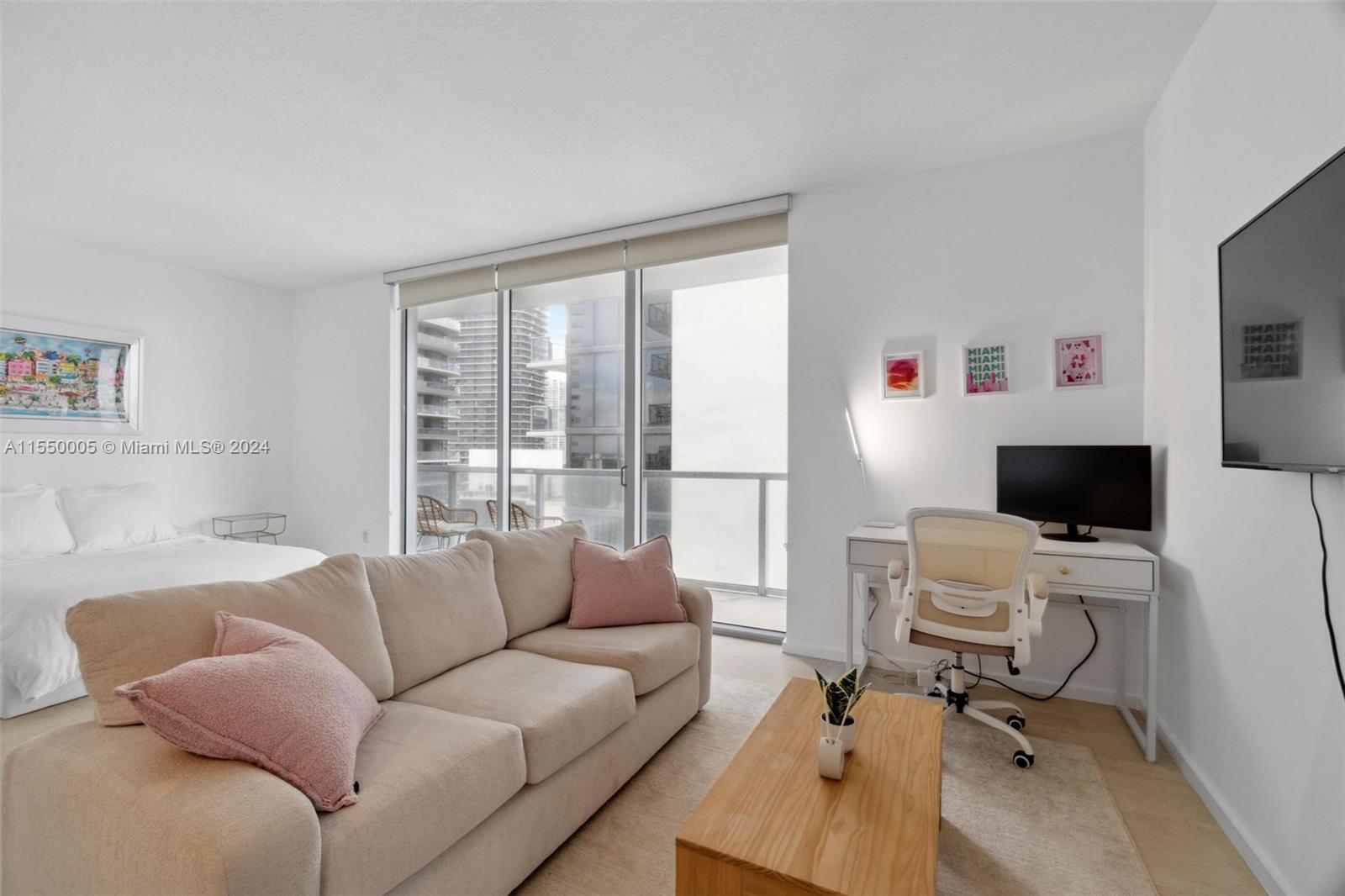 1050 Brickell Avenue, Unit 2422 Miami, FL 33131 - Photo 9 of 21 a living room with furniture and a flat screen tv