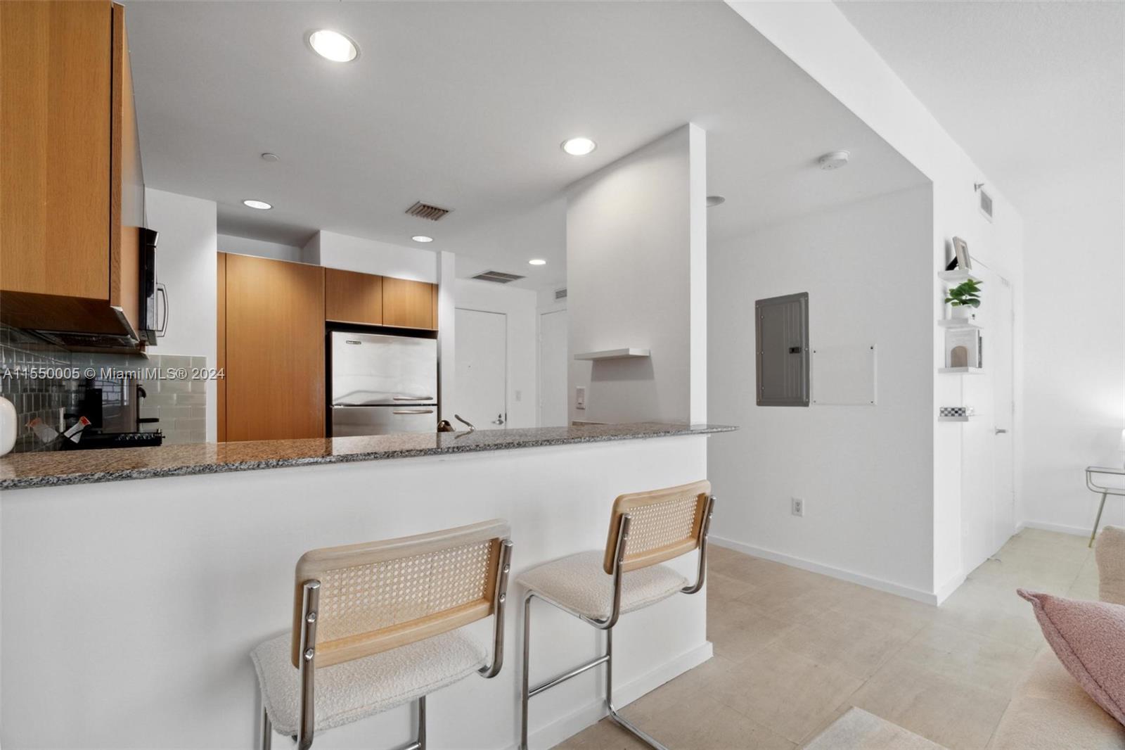 1050 Brickell Avenue, Unit 2422 Miami, FL 33131 - Photo 10 of 21 a kitchen with stainless steel appliances granite countertop a sink and a refrigerator