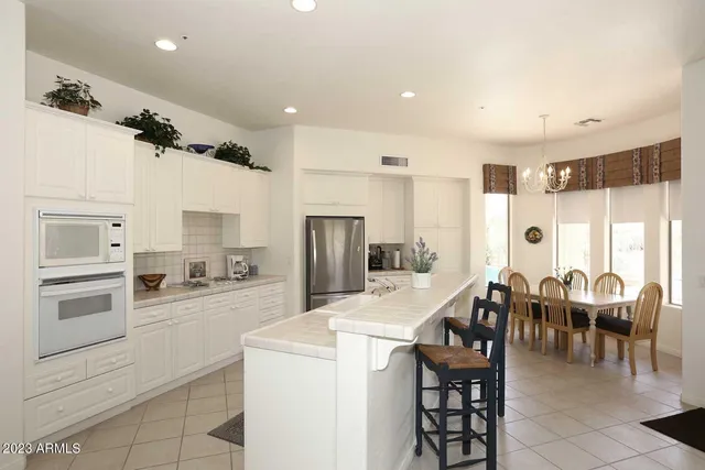 a large living room with stainless steel appliances furniture and a view of kitchen