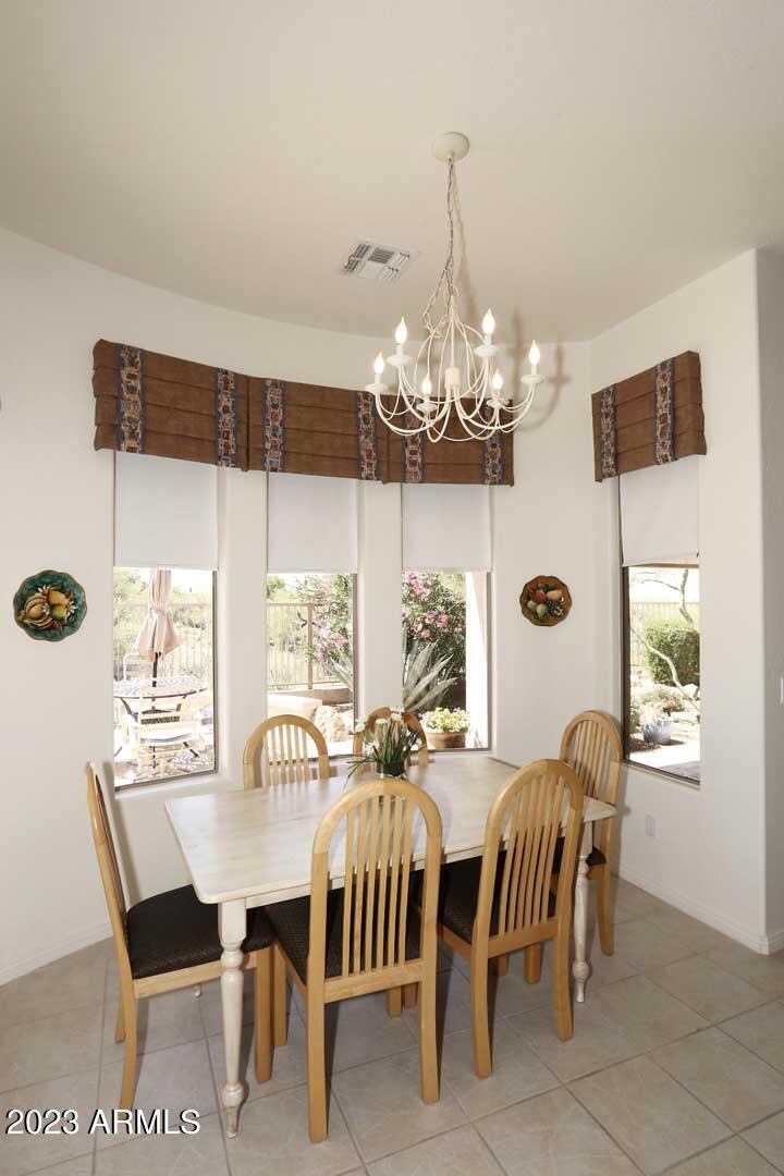 6335 East Marioca Circle Scottsdale, AZ 85266 - Photo 14 of 66 a view of a dining room with furniture a chandelier and large windows