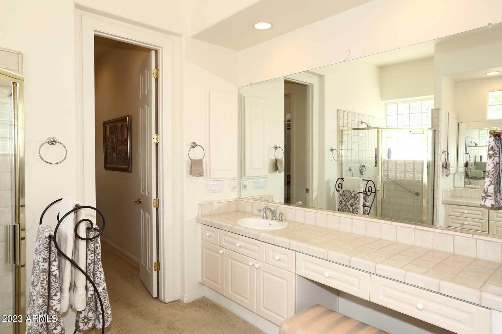 6335 East Marioca Circle Scottsdale, AZ 85266 - Photo 24 of 66 a spacious bathroom with a shower sink and mirror