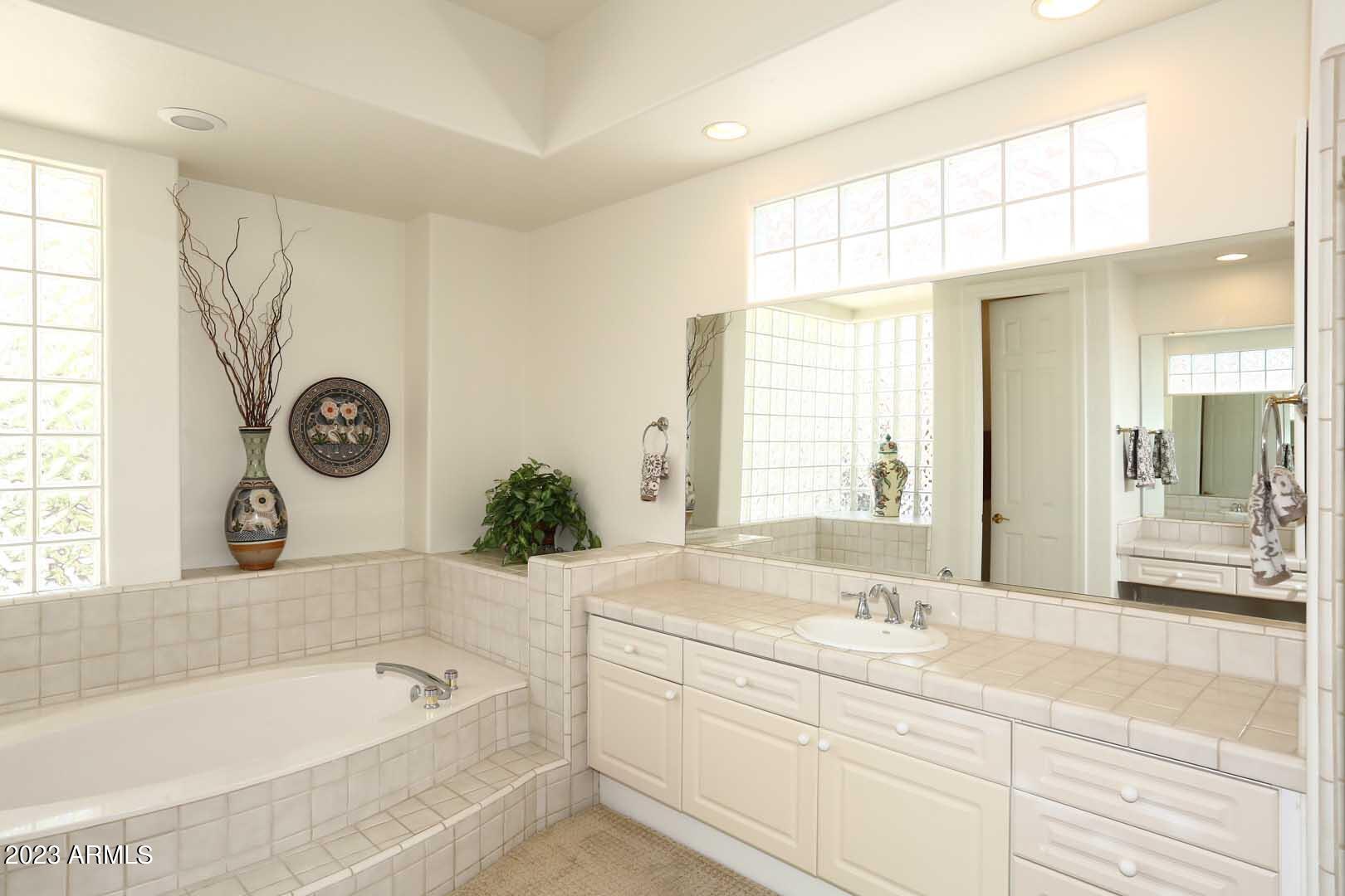6335 East Marioca Circle Scottsdale, AZ 85266 - Photo 25 of 66 a bathroom with a tub sink and mirror