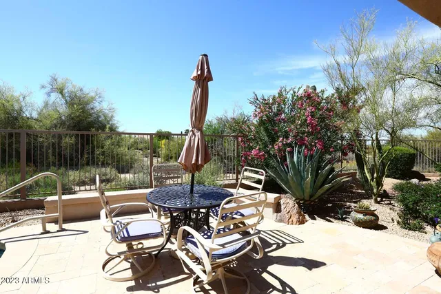 a view of a patio with dining table and chairs