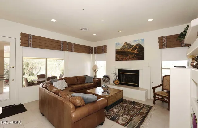 a living room with furniture a fireplace and a flat screen tv