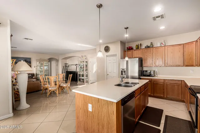 a kitchen with a sink a counter top space stainless steel appliances and cabinets